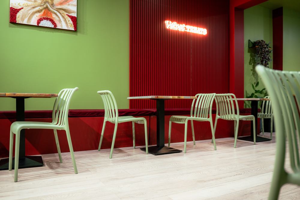 Mint green chairs and timber tables along the red banquette
