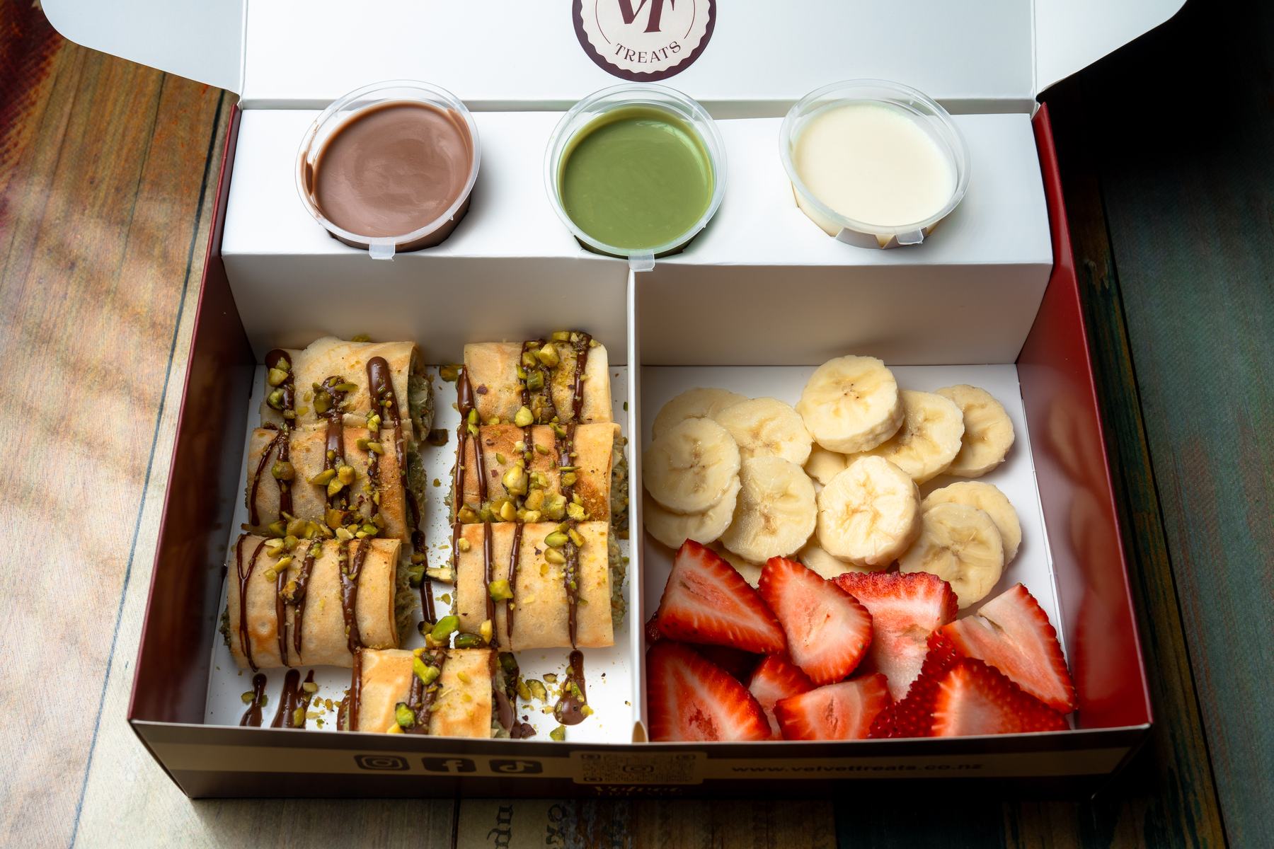 A Velvet Treats sushi crepe box with dipping sauces and fresh fruit